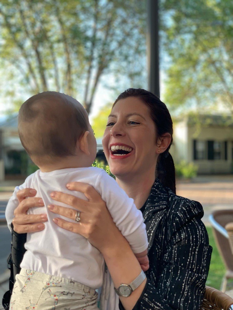 Valerie laughing while holding a baby